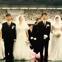 Two couples, grooms in black suits and women in long white wedding dresses