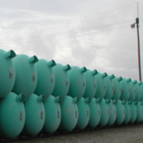 Dozens of blue green barrels lined up