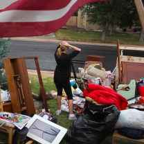 Woman outside in a yard full of furniture after eviction