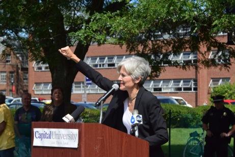 Jill Stein raising her fist at the podium