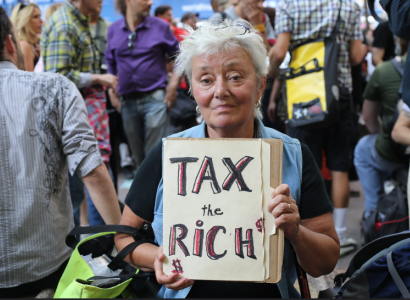 Woman holding Tax the Rich sign