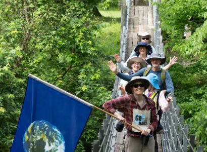Marchers posing on a bridge in the woods