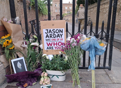 Memorials with flowers and a sign about Jason Arday