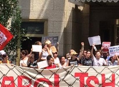 Words Abolish ICE real big on a sign behind people protesting