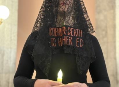 Woman in funeral clothes with a candle