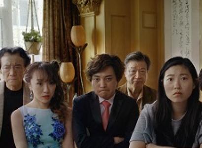 Very serious faced Asian people posing at a table all dressed up