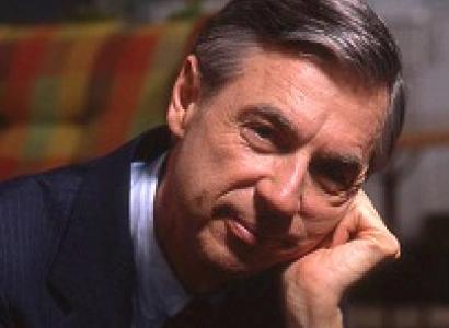 Older white man with dark and gray hair wearing a suit with his head resting on his hand