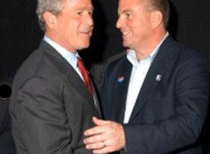 Two middle aged white men shaking hands very close together