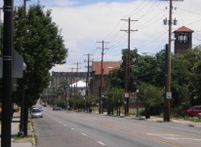 Street scene with a tower and trees and a lightpost and electricity poles
