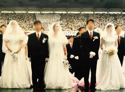 Two couples, grooms in black suits and women in long white wedding dresses