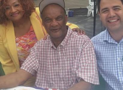 Calvin at a table outside with a woman to his right and man to his left