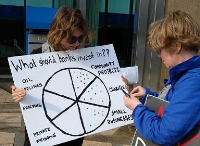 Girl holding sign about how Chase bank makes investments