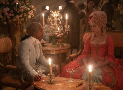 Two Victorian looking people standing by a table