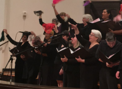 Women singing and waving scarves