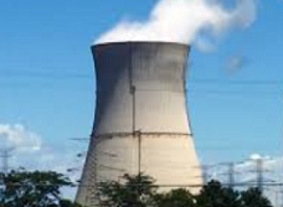 Big nuclear power plant smokestack with white smoke billowing out