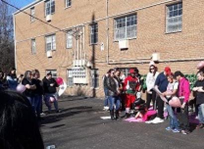 People outside a brick building with posters and signs