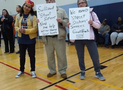 Esther and Gary Witte and Winie Wirth holding signs