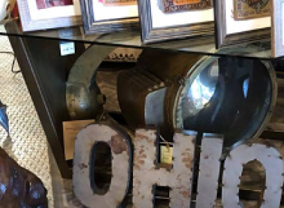 A bunch of photos on a shelf and the word Ohio cut out of metal on the floor