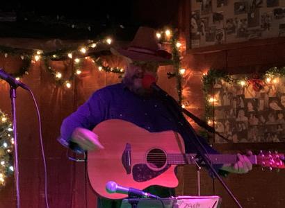 Guy in Cowboy hat playing a guitar