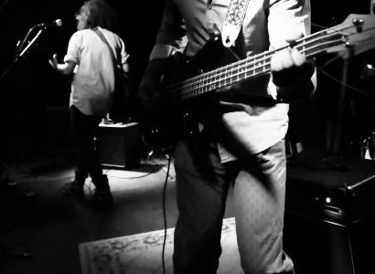 Black/white photo of guy playing a guitar in a band