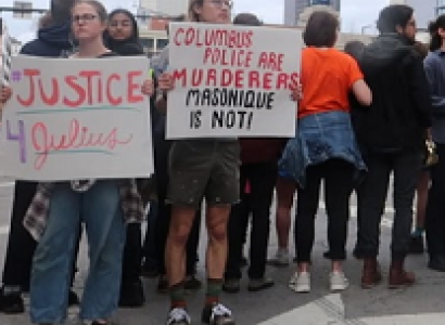 People outside downtown holding signs that say Justice 4 Julius and Columbus Police are murderers Masonique is not