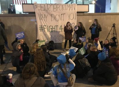 People protesting and sign saying Portman why don't you Fight4her