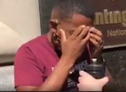 Black man with his head in his hands