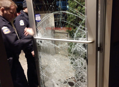Shattered glass door and policemen