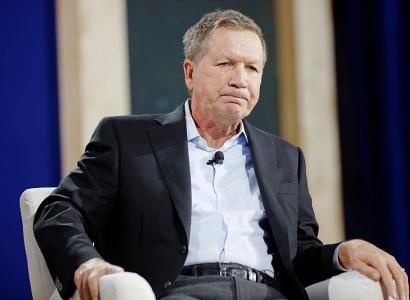 Kasich sitting and making a face