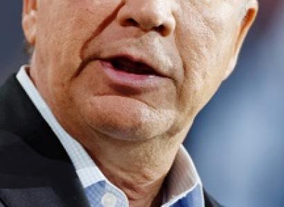 Extreme close up of white man with gray hair talking out the side of his mouth