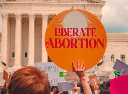 Sign in front of government building saying Liberate Abortion