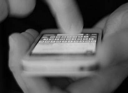 Hand typing onto a cellphone