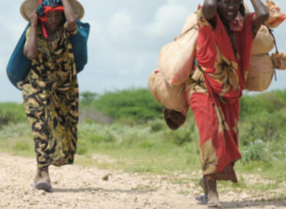 Immigrant women walking on dirt path in Africa