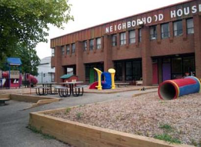 A brick building with words Neighborhood House on it