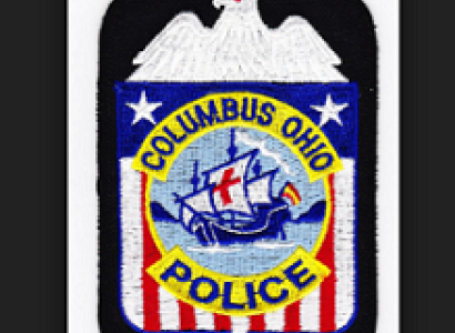 Red white and blue police badge with eagle at top and Santa Maria in the middle with words Columbus Ohio police