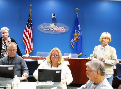People doing a recount at tables with flags in the background