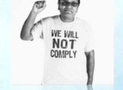 Latino man holding up a fist with a t-shirt saying we will not comply