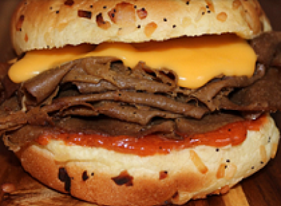 Big bun burger-looking sandwich close-up except it's like layers of beef (though not meat) with cheddar cheese (though not cheese)