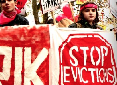 People holding signs saying Stop Evictions