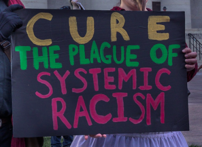 Sign saying Cure the Plague of Systemic Racism