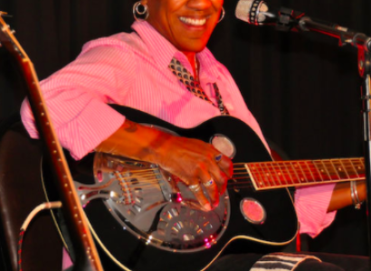 Gaye Adegbalola playing a guitar
