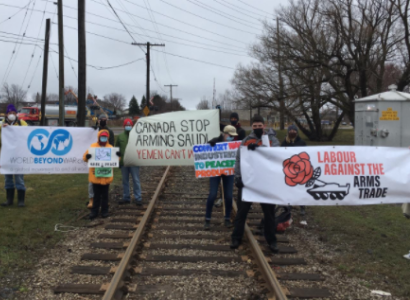 People holding signs on a railroad track