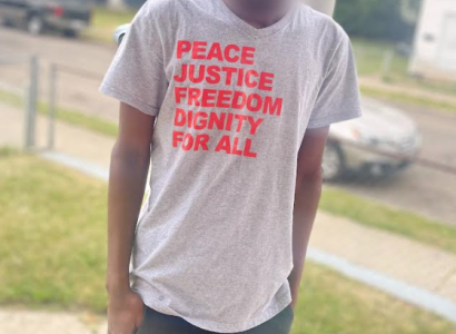 Man in T-shirt saying Peace, Justice, Freedom, Dignity for all