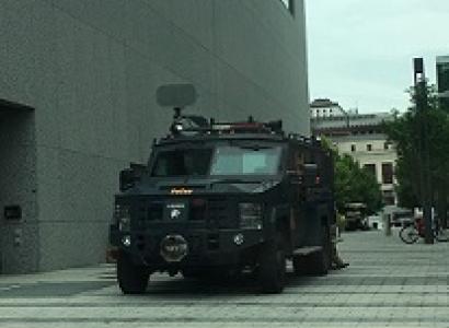 Large army-looking tank coming out of a narrow street