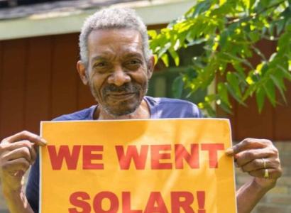 Man holding We Went Solar sign
