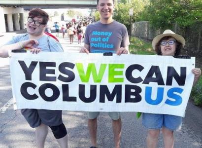 People outside holding a Yes We Can banner