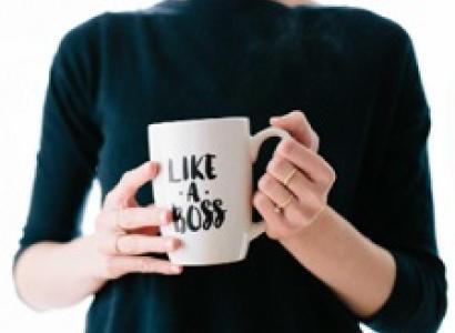 Woman's torso with hands holding mug that says Like a Boss