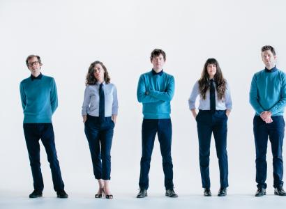 Four white people standing in a row dressed the same
