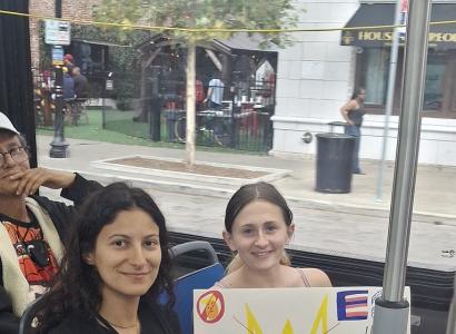 Young women with signs on a bus