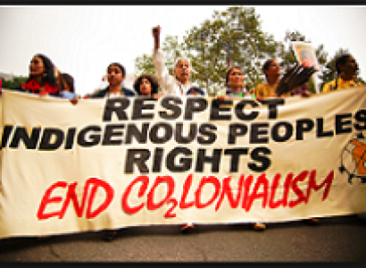 People marching outside with a huge banner that reads Respect Indigenous People's Rights End colonialism